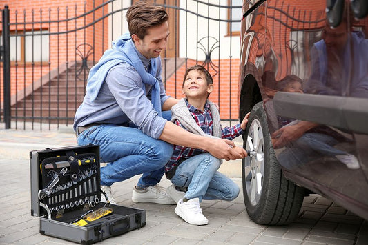 Dad teaching son life skills how to change a tire