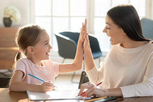 Mom high-fiving daughter homeschooling with positive reinforcement