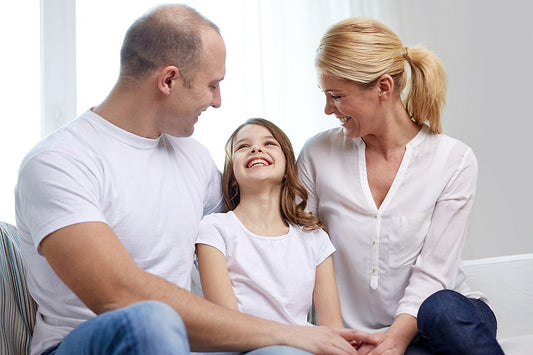 Parents talk with and listen to their daughter, practicing parent-child communication.